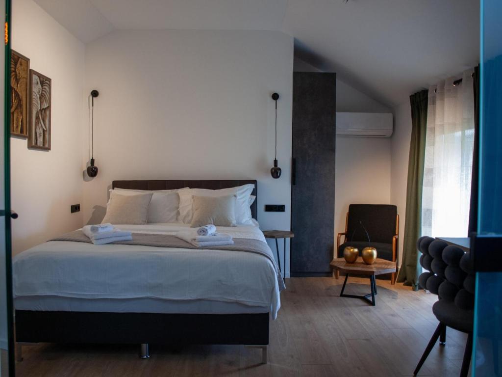 ein Schlafzimmer mit einem großen Bett und einem Stuhl in der Unterkunft NOVA LUXURY DESIGN in Zagreb