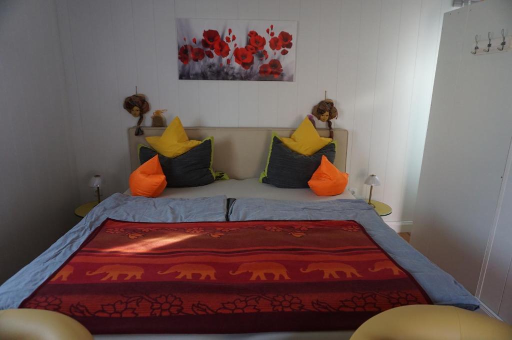 MüchelnにあるFerienwohnung Maurerのベッドルーム1室(オレンジと青の枕が付いたベッド1台付)