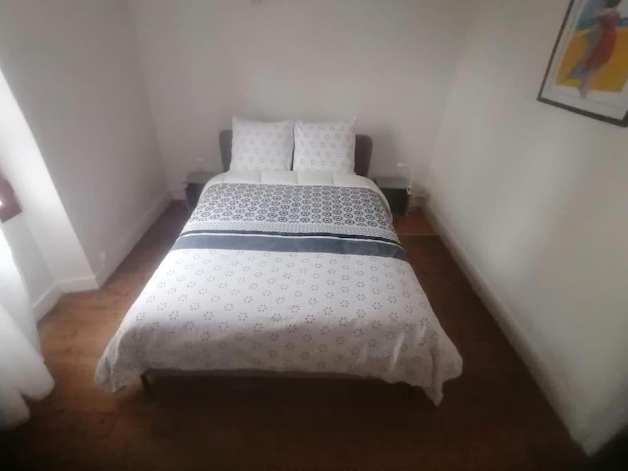 een slaapkamer met een bed met een wit dekbed bij Maison entre ville et campagne in Amilly
