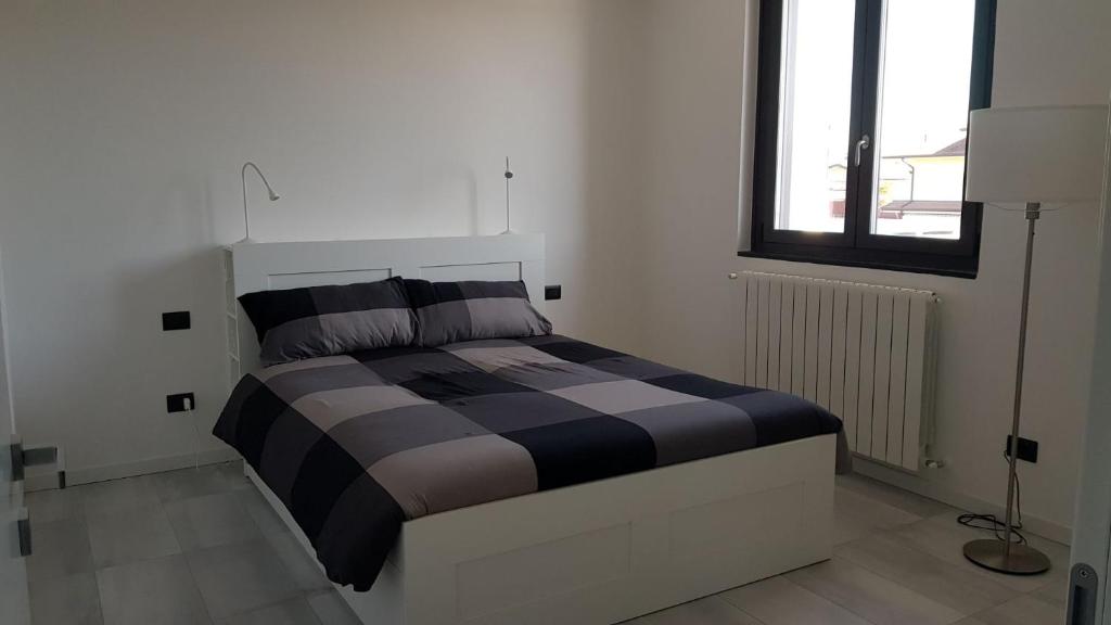 una camera da letto con un letto in una stanza con una finestra di Black and White B&B Urgnano a Urgnano