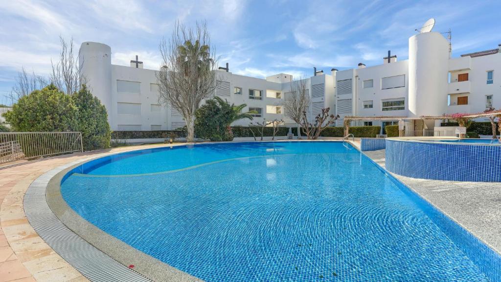 a large blue swimming pool in front of a building at Bellresguard Garden Flat C in Port de Pollensa