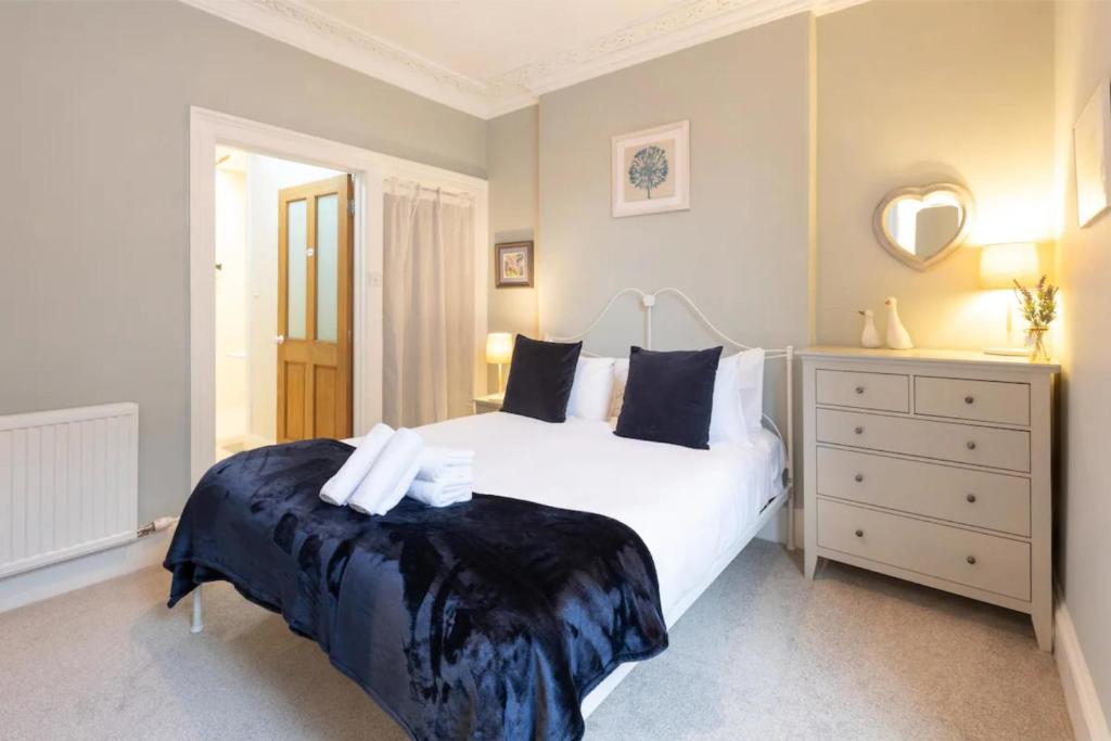 エディンバラにあるBeautiful 1 Bedroom Flat in Vibrant Stockbridgeのベッドルーム(大きな白いベッド1台、ドレッサー付)