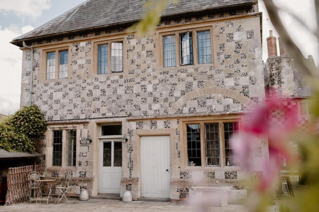 a large brick house with a white door at The Courtyard at Manor Estate near Stonehenge in Salisbury
