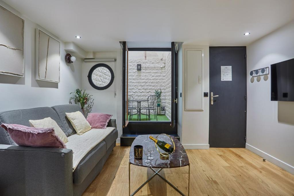 un salon avec un canapé et une table dans l'établissement Apartment St Honore by Studio prestige, à Paris