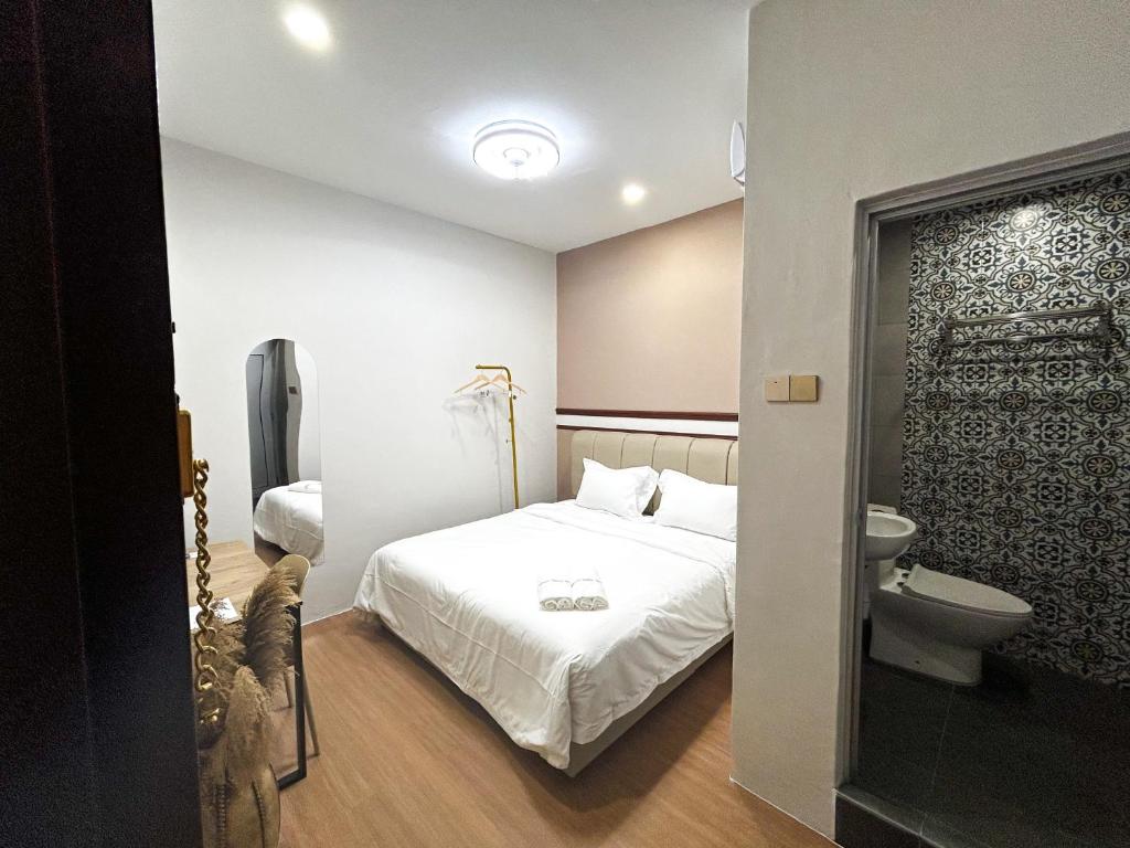 a small bedroom with a bed and a toilet at Mana Mana Hotel • Melaka • in Melaka