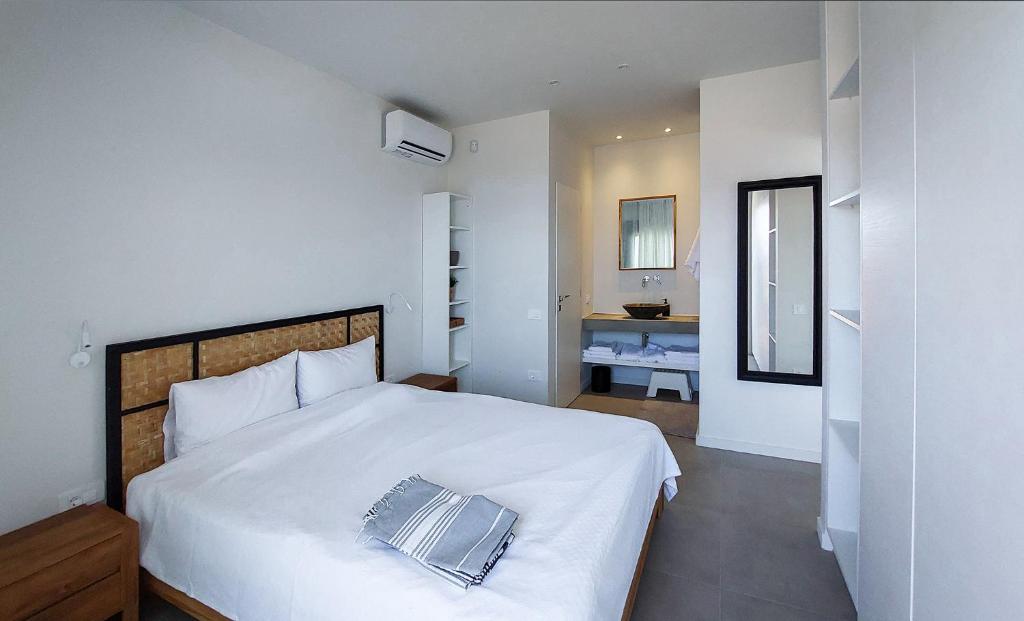 een slaapkamer met een groot wit bed en een badkamer bij Villa Anna in Paleros
