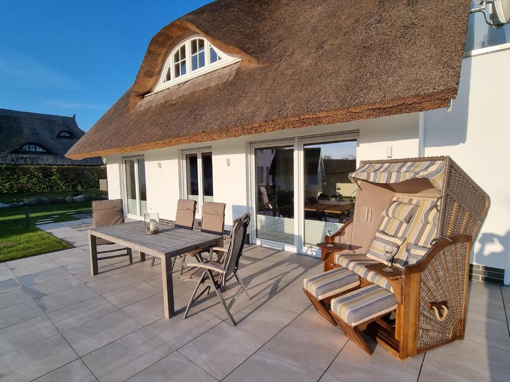 une terrasse avec une table et des chaises ainsi qu'une maison dans l'établissement Landhaus Wreechen mit Sauna, à Putbus