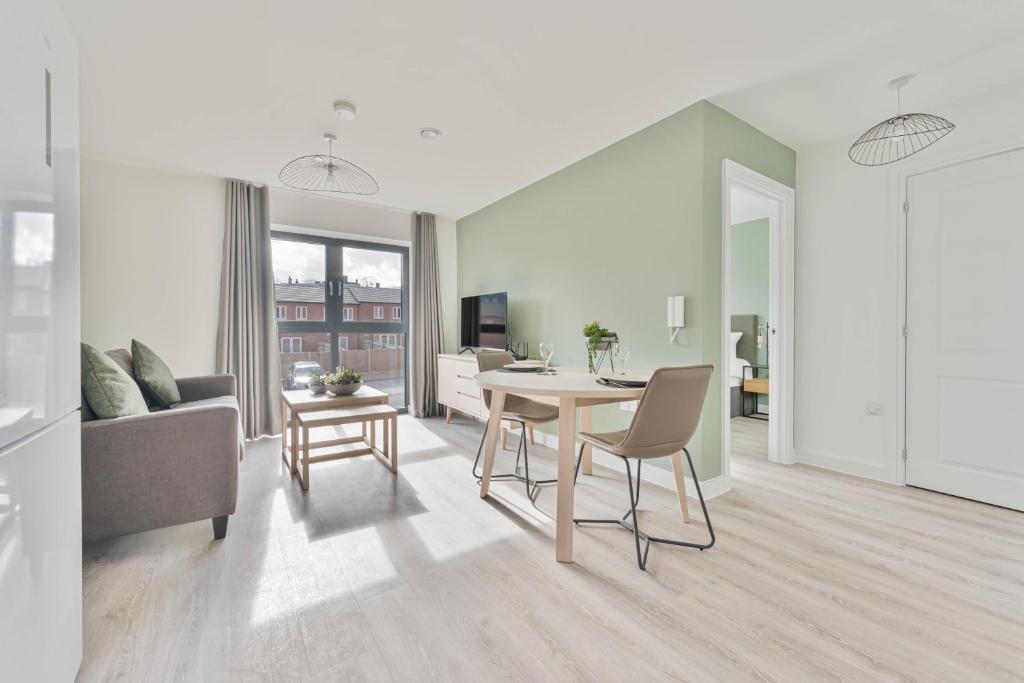 ein Wohnzimmer mit einem Tisch und einem Sofa in der Unterkunft Modern 1 Bed Apartment, Nightingale Quarter Derby in Derby
