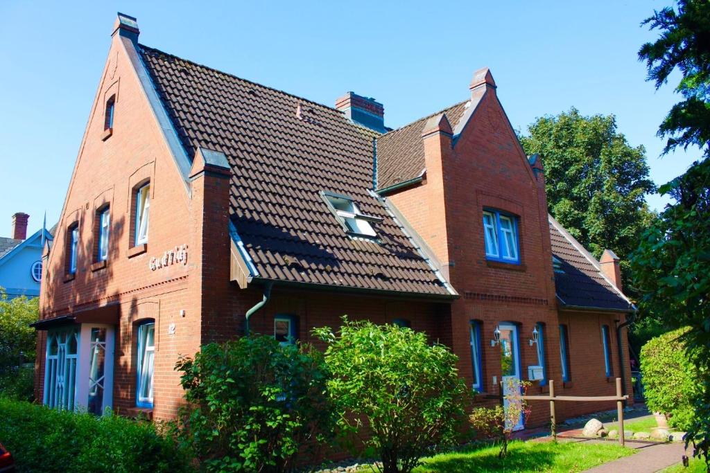 a red brick house with a black roof at Gud Tidj - Whg 03 in Wyk auf Föhr