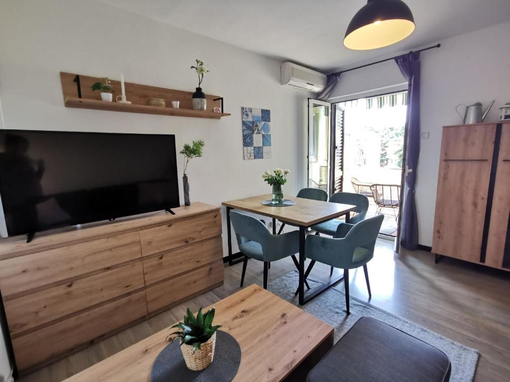 ein Wohnzimmer mit einem großen TV und einem Tisch in der Unterkunft Studio für 4 Personen ca 37 qm in Rovinj, Istrien Istrische Riviera in Rovinj