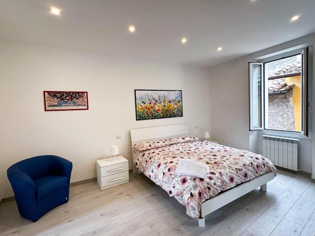 1 dormitorio con 1 cama y 1 silla azul en San Vincenzo, en Tívoli
