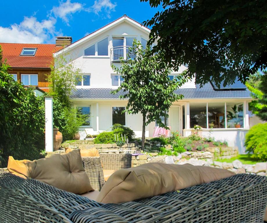 un canapé en osier assis devant une maison dans l'établissement Haus See-und Säntisblick "EG", à Friedrichshafen