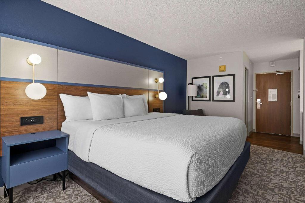 a bedroom with a large bed with a blue wall at AmericInn by Wyndham Casper Event Center Area in Casper