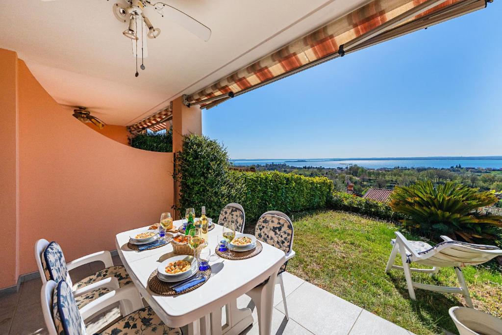 een eetkamer met een tafel en stoelen op een patio bij Residence Giardino 3 by Wonderful Italy in Soiano del Lago