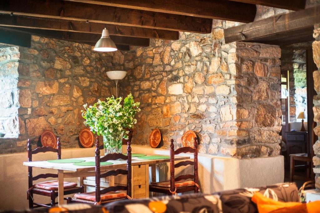 een tafel met stoelen en een vaas met bloemen erop bij Ferienwohnung für 4 Personen ca 50 qm in Carucedo, Kastilien-Leon Provinz Len in Carucedo
