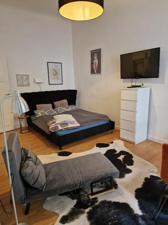 - un salon avec un lit et une télévision dans l'établissement Appartement Berlin Charlottenburg, à Berlin