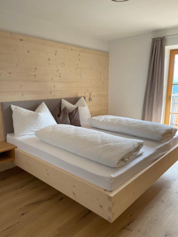 a bedroom with two beds with white sheets and pillows at Ferienhaus Gann - Greit in Villandro