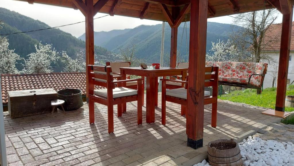 una mesa y sillas en un patio con vistas en Ljubov kutak en Mokra Gora