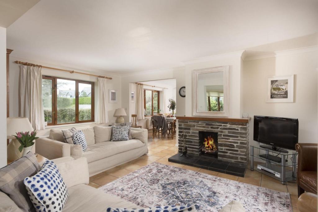 a living room with a couch and a fireplace at Godolphin in Wadebridge