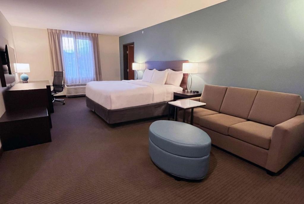 a hotel room with a bed and a couch at La Quinta Inn & Suites by Wyndham Wenatchee in Wenatchee