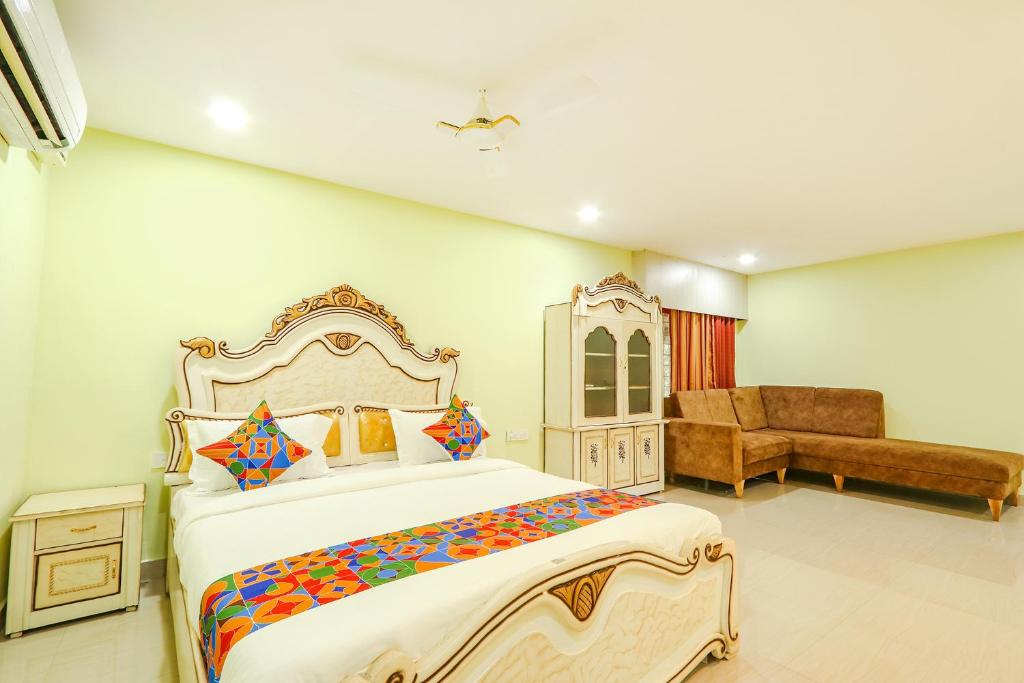 a bedroom with a large bed and a chair at FabHotel Prime JVS Beauty Green Resorts in Venkatāpur