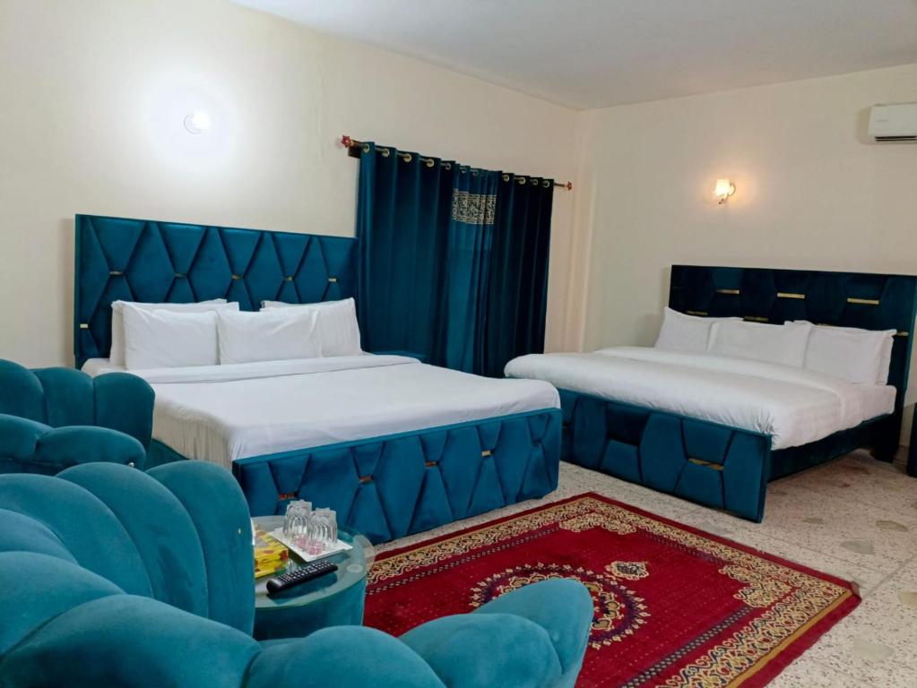 een hotelkamer met twee bedden en een bank bij Luxury Moon Guest House in Islamabad