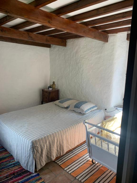 a bedroom with a bed and a wooden ceiling at Grande maison cévenole authentique in Valleraugue
