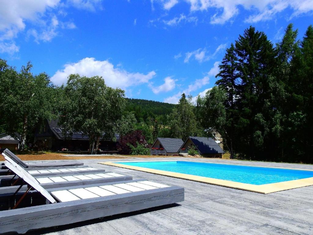 een zwembad met ligstoelen bij Gemütliche BERGHüTTE-1 am Bach mit Zugang zur Sauna, heißen Badewanne und Pool in Szklarska Poręba