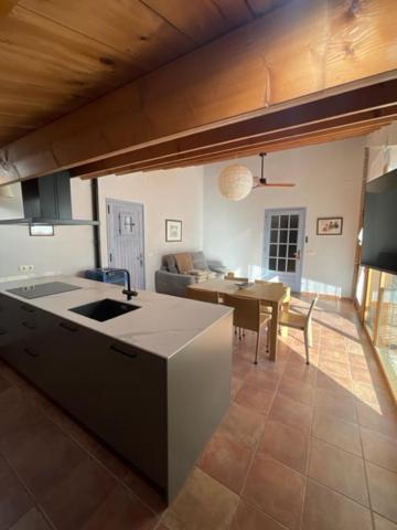 uma cozinha e sala de estar com uma mesa e um sofá em Casa Rural Can Titus em L’ Esquirol