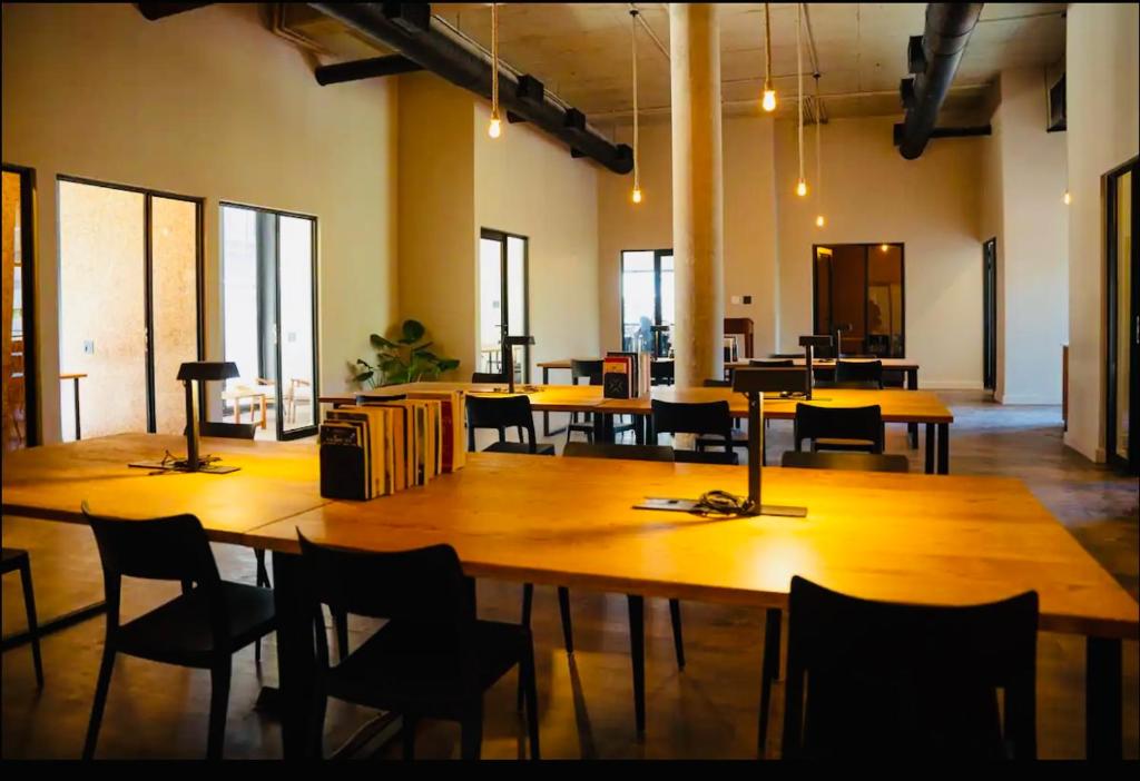 una grande stanza con tavoli, sedie e finestre di Executive Studio Apartment in Sandton a Johannesburg