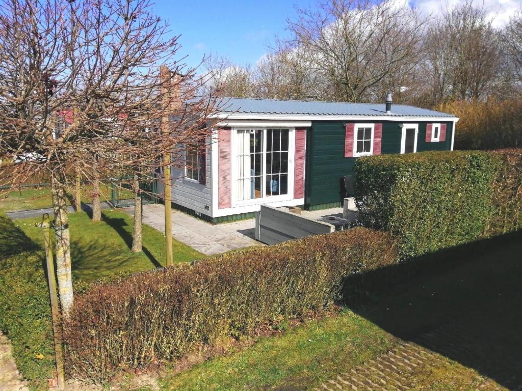 Baarland的住宿－Ferienhaus für 5 Personen 1 Kind ca 41 qm in Baarland, Zeeland Küste von Zeeland，一座红色绿色的小房子