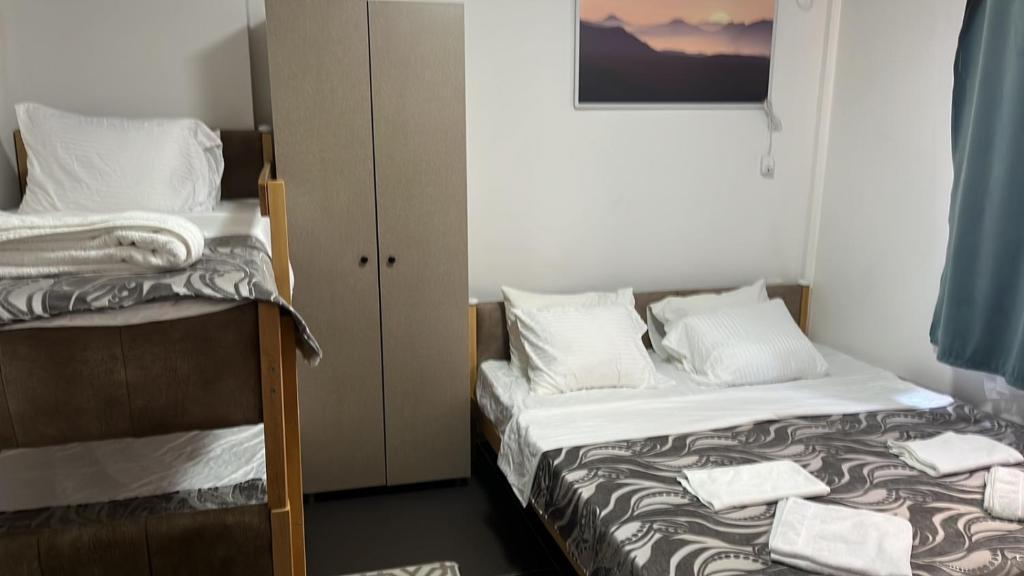 a bedroom with two beds and a bunk bed at Hotel City Rooms Prishtina in Pristina