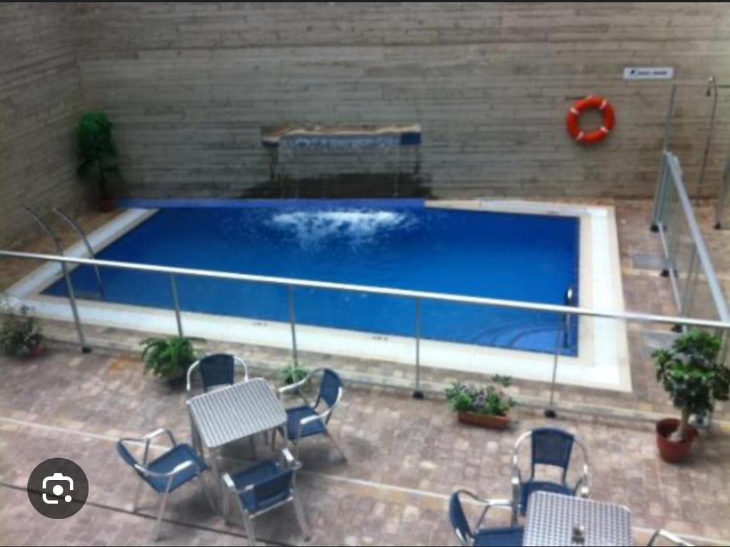 a swimming pool with chairs and a red life preserver at ALBERGUE CASA MARIELA solo peregrinos con credenciales in Torres del Río