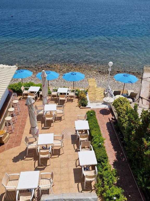 a group of tables and chairs with blue umbrellas at Porto Xronia in Khrónia