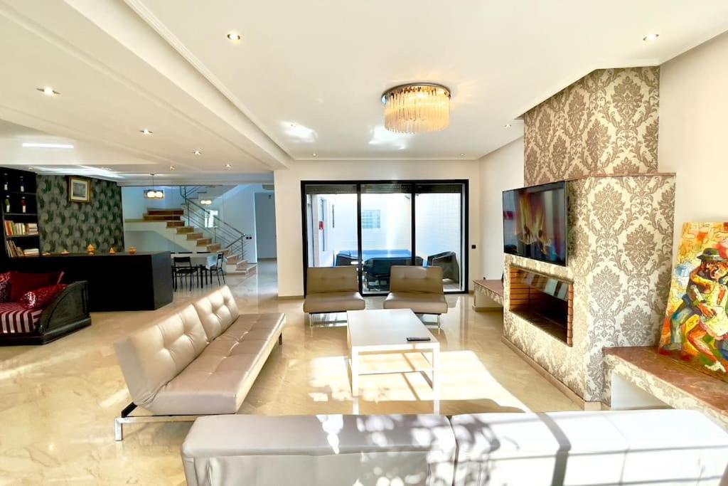 uma sala de estar com um sofá e uma lareira em Luxury villa with private pool em Casablanca