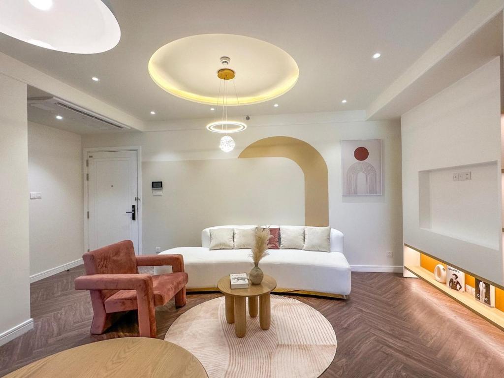uma sala de estar com um sofá branco e uma mesa em Luxury Apartment Altara em Quy Nhon