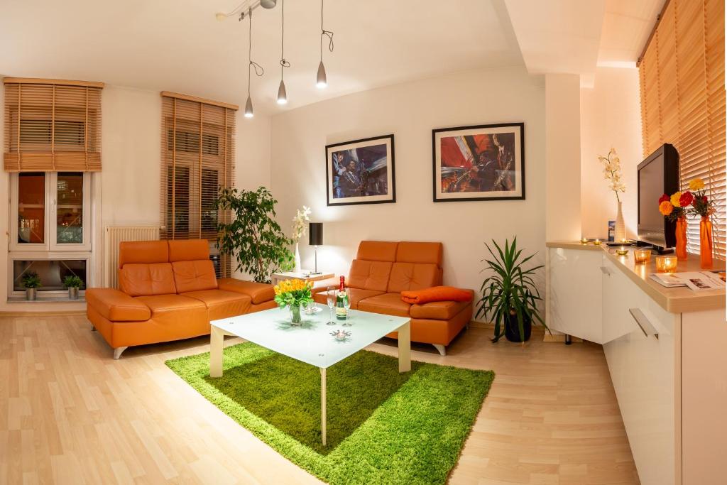 a living room with orange chairs and a table at Gemütliches kleines Apartment in Dresden