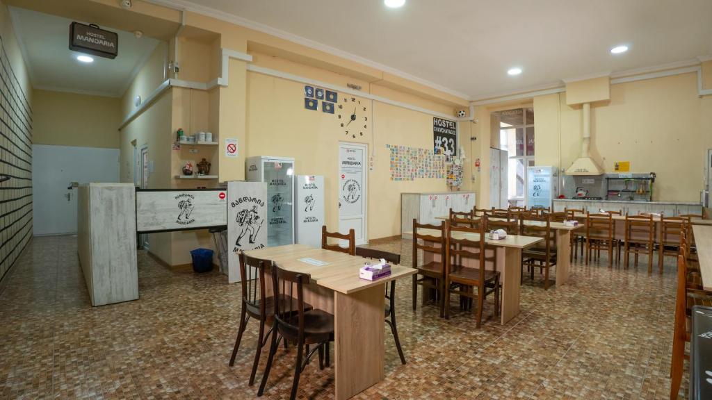a restaurant with tables and chairs in a room at Hostel Mandaria in Kutaisi