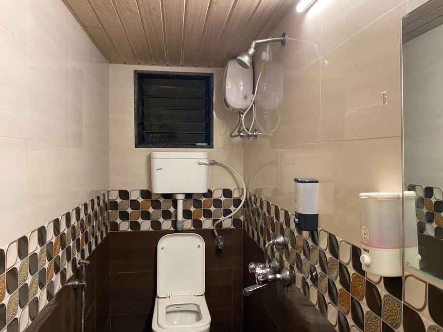 a bathroom with a toilet and a window at Imagine Harmony in Lonavala