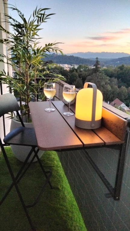 - une table avec deux verres de vin sur le balcon dans l'établissement Appartement Pau, à Pau