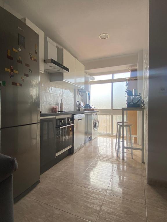 uma cozinha com electrodomésticos de aço inoxidável e uma grande janela em Sunrise beach em Santa Pola