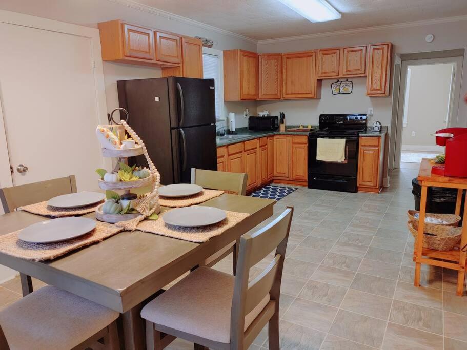 a kitchen with a table with chairs and a refrigerator at Quiet Country Small Family Home 5 minutes from town in Mansura