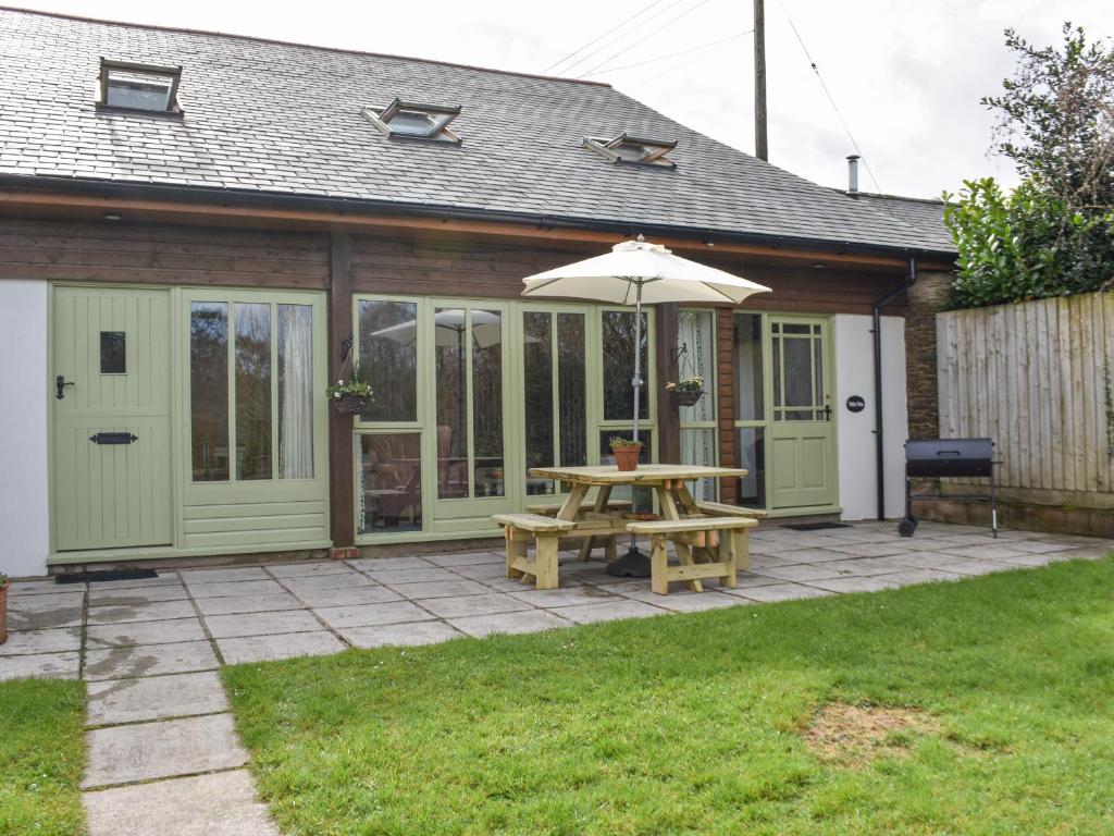 a patio with a picnic table and an umbrella at Valley View in Barnstaple