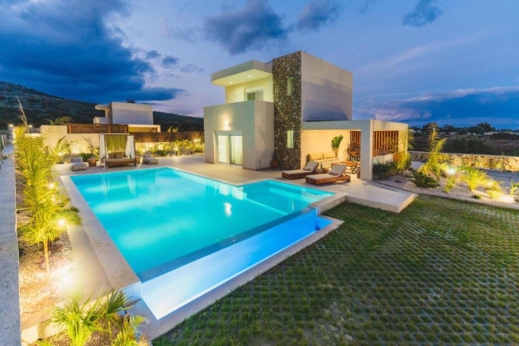 a villa with a swimming pool at night at Cleopatra's Villa Luxury Retreat South Rhodes in Lachania