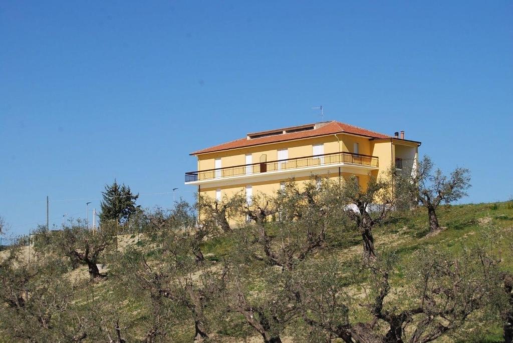 un edificio en la cima de una colina con árboles en Ferienwohnung für 4 Personen ca 45 qm in Offida, Adriaküste Italien Küste der Marken, en Offida