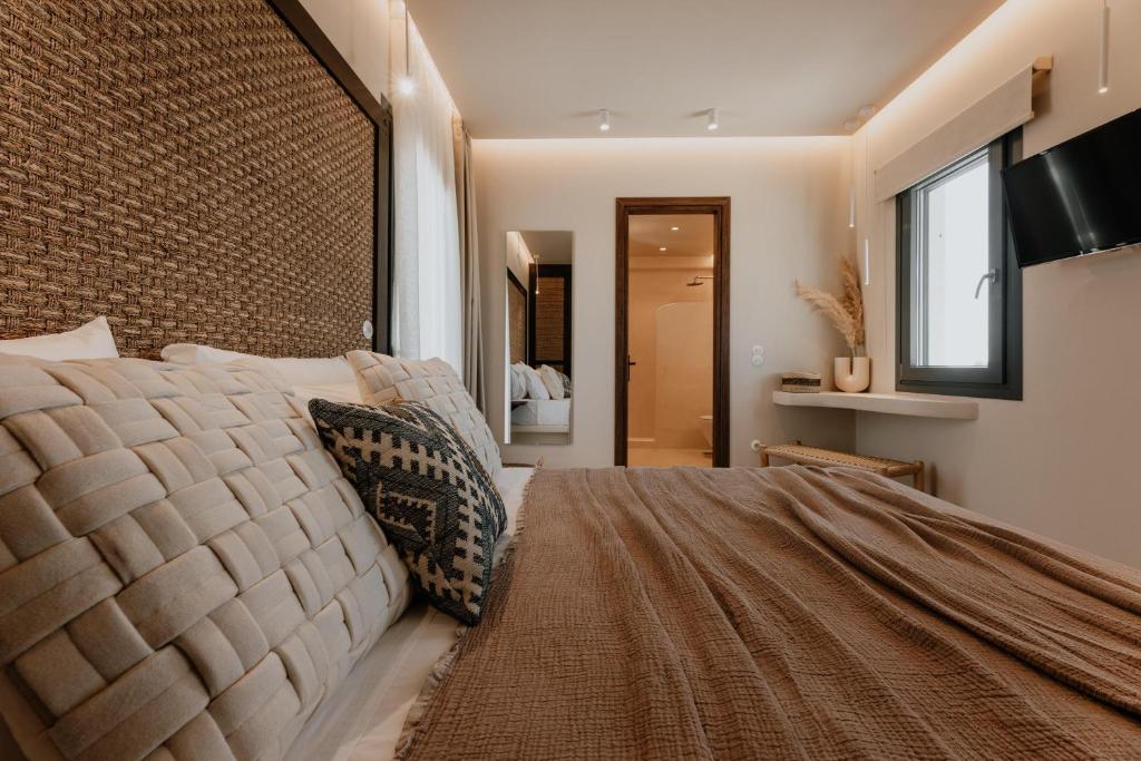 um quarto com uma cama grande e uma janela grande em ONYM Curated Villas em Plaka