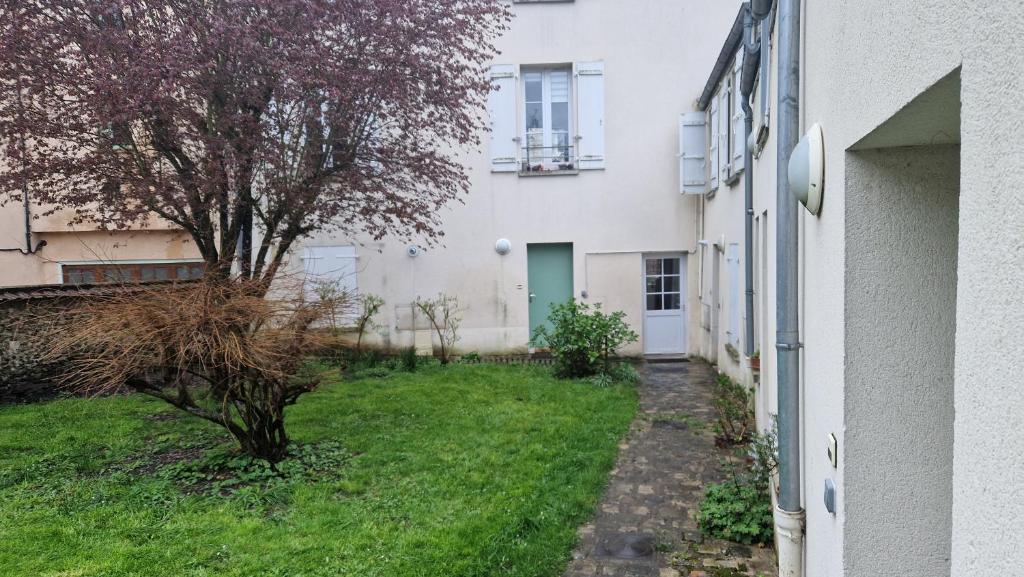 um pátio vazio ao lado de um edifício branco em Appartement 2 pièces RDC em Rambouillet