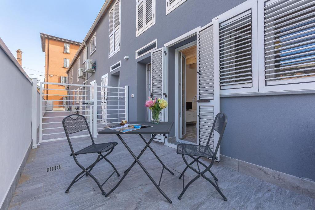 a patio with two chairs and a table on a balcony at Casa Gemma Comfortable Apartment in Bologna