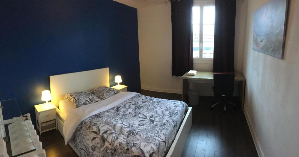 a bedroom with a bed with two lamps and a desk at Bel appartement à Dijon 2 in Dijon