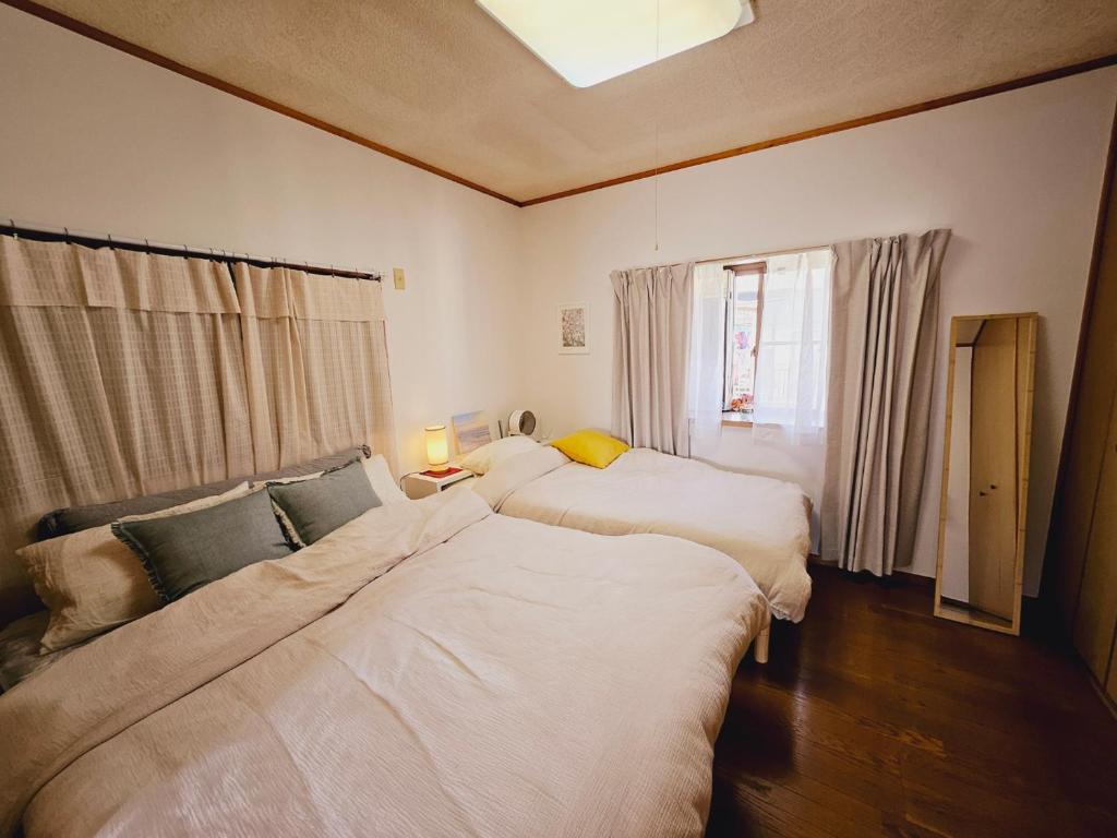 a bedroom with two beds and a window at AsahiStay -Koiwa, Free parking O, Whole Family House, Japanese garden taste in Tokyo